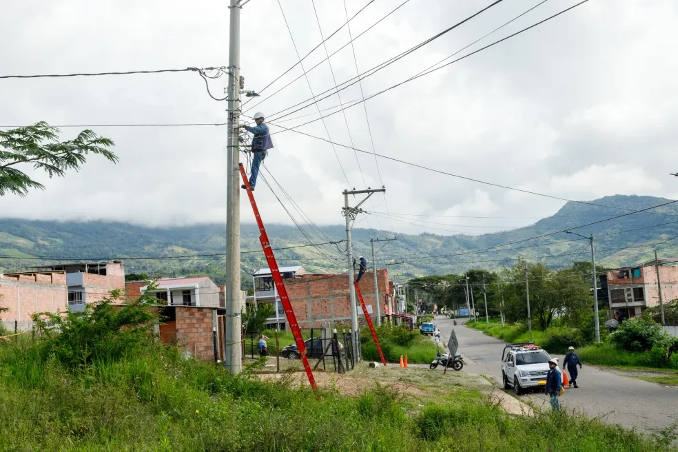 Equipo de Space Infinite instalando fibra óptica en postes con montañas de fondo